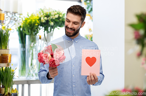 Image of happy man with flowers and valentine's day card