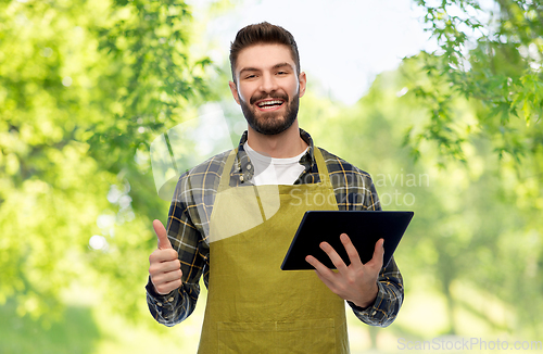 Image of happy male gardener or farmer with tablet pc