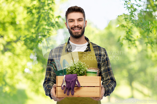 Image of happy gardener or farmer with box of garden tools