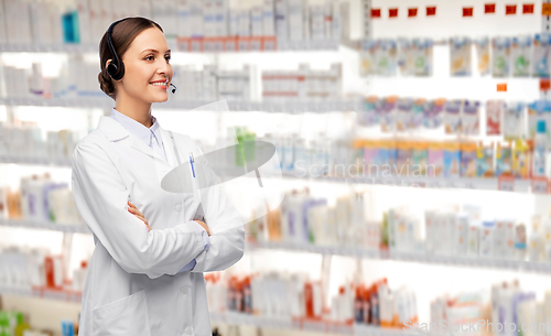 Image of smiling female doctor with headset at pharmacy