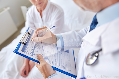 Image of senior woman and doctor with clipboard at hospital