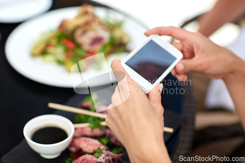 Image of couple with smatphone photographing food