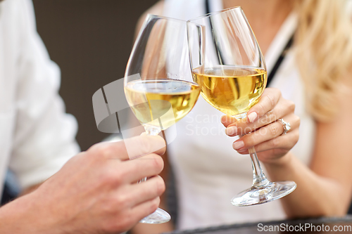 Image of close up of couple clinking wine glasses