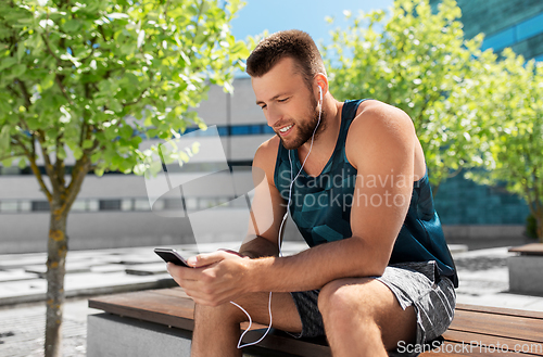 Image of young athlete man with earphones and smartphone