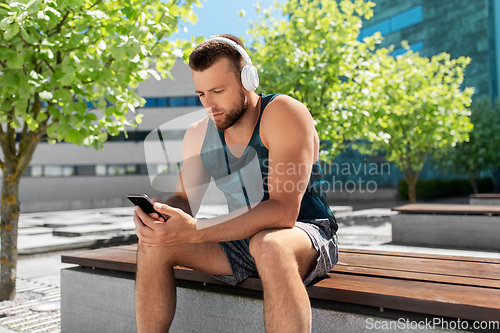 Image of young athlete man with headphones and smartphone