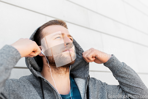 Image of man in earphones listening to music outdoors