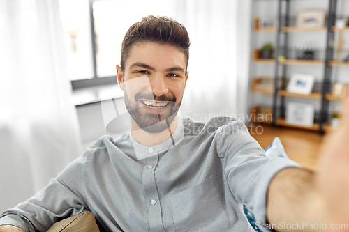 Image of man taking selfie or having video call at home