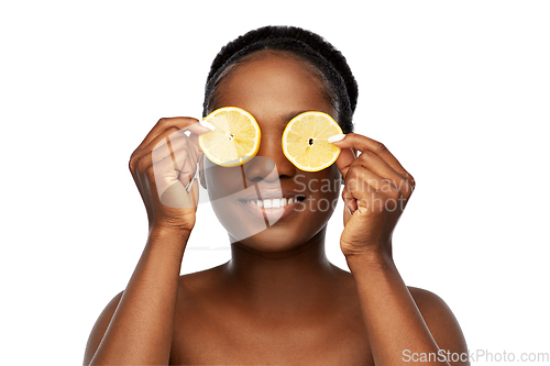 Image of african american woman making eye mask of lemons