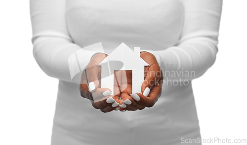 Image of hands of african american woman holding house