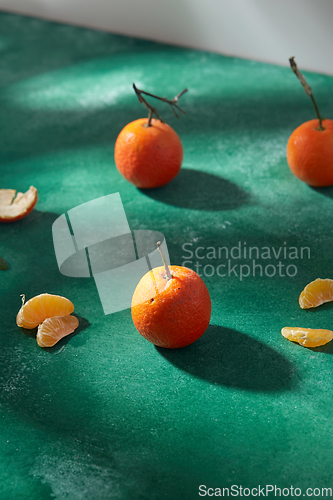 Image of still life with mandarins on green background