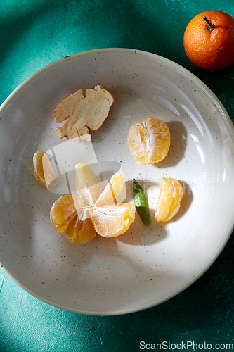 Image of still life with peeled mandarins on plates