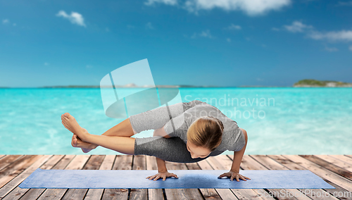 Image of woman making yoga in handstand over ocean