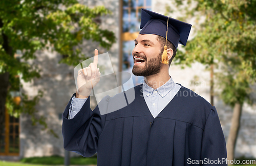 Image of happy graduate student pointing his finger up