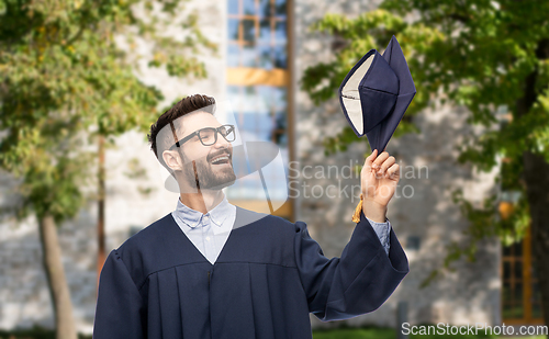 Image of graduate student in bachelor gown with mortarboard