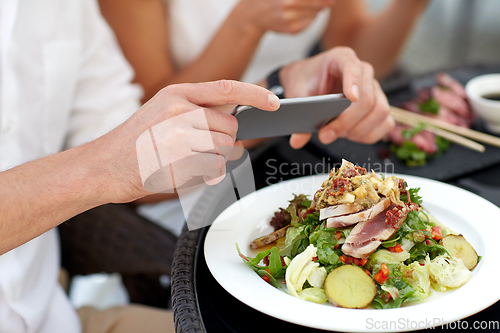 Image of couple with smatphone photographing food