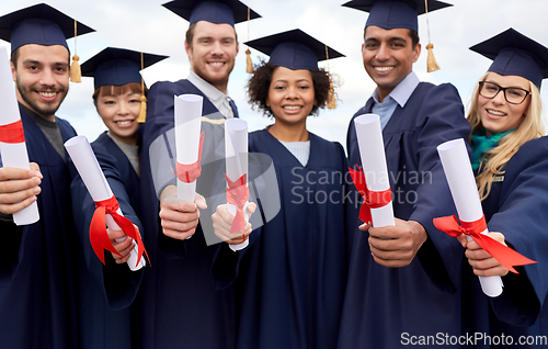 Image of graduate students in mortar boards with diplomas