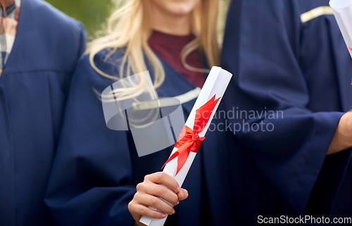 Image of graduate students in mortar boards with diplomas