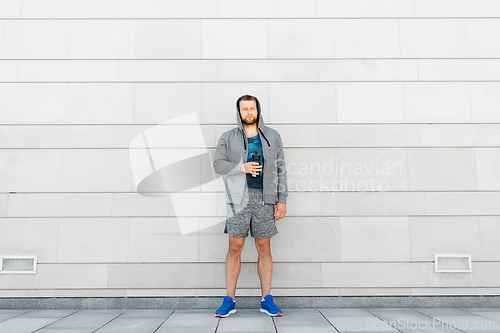 Image of sportsman with bottle of water in city