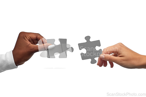 Image of black and white hands matching pieces of puzzle