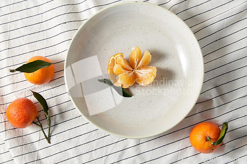 Image of still life with mandarins on plate over drapery