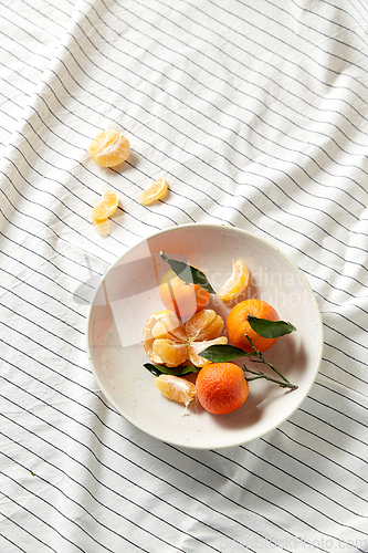 Image of still life with mandarins on plate over drapery