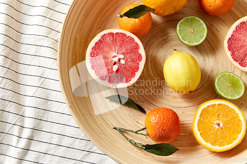 Image of close up of citrus fruits on wooden plate