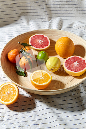 Image of close up of citrus fruits on wooden plate