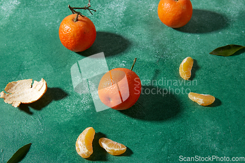 Image of still life with mandarins on green background