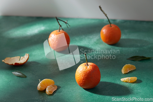 Image of still life with mandarins on green background