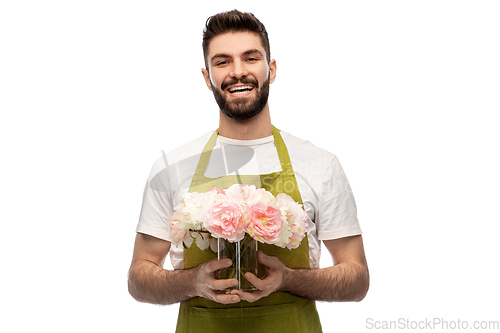 Image of smiling male gardener with bunch of peony flowers