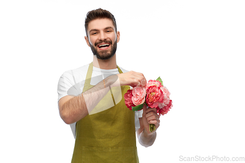 Image of smiling male gardener with bunch of peony flowers