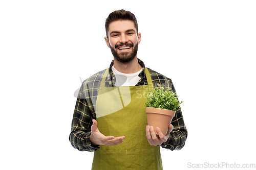 Image of happy smiling male gardener with flower in pot