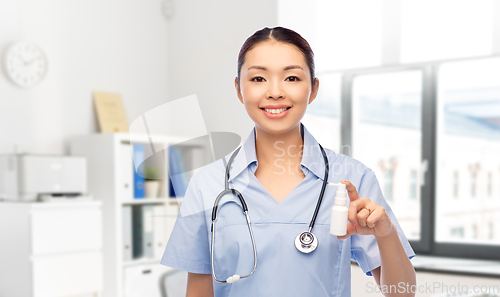 Image of smiling asian female doctor or nurse with medicine