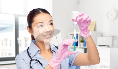 Image of happy asian female nurse with medicine and syringe