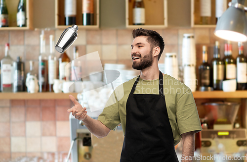 Image of happy barman with shaker preparing drink at bar