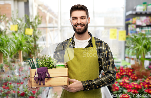 Image of happy gardener or seller with box of garden tools