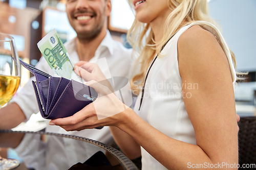 Image of close up of couple with money paying at restaurant