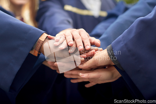 Image of inernational graduate students stacking hands