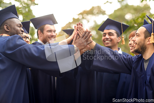 Image of international graduate students making high five