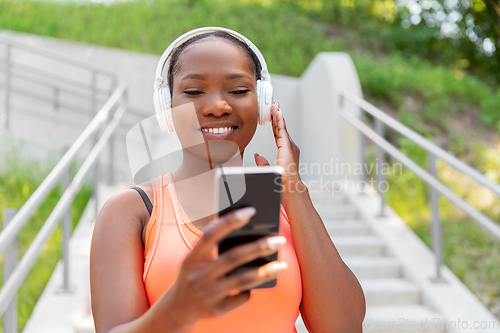 Image of african american woman with headphones and phone