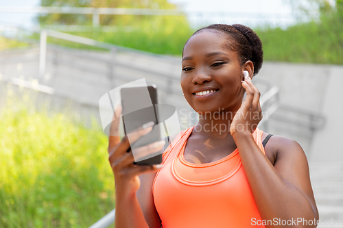 Image of african american woman with earphones and phone