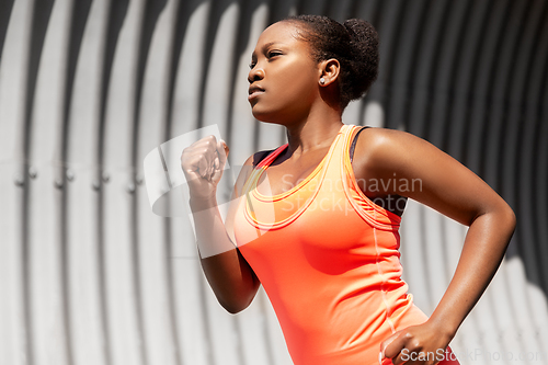 Image of young african american woman running in tunnel