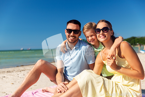 Image of family hugging on summer beach