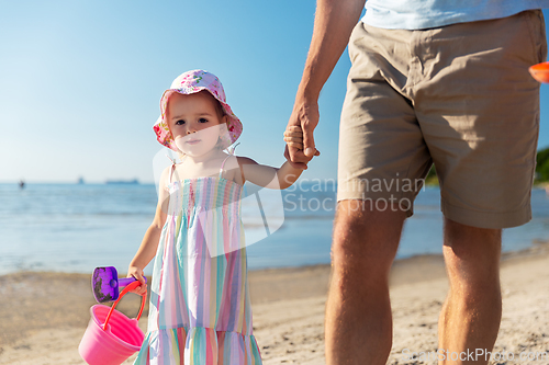 Image of father walking with little daughter on beach