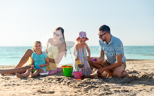 Image of happy family with daughters on summer beach