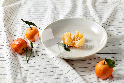 Image of still life with mandarins on plate over drapery