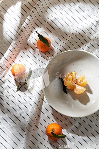 Image of still life with mandarins on plate over drapery