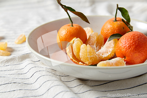 Image of still life with mandarins on plate over drapery