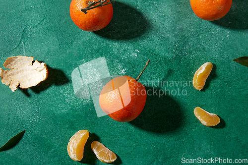 Image of still life with mandarins on green background