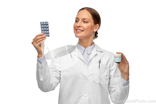 Image of smiling female doctor holding medicine pills